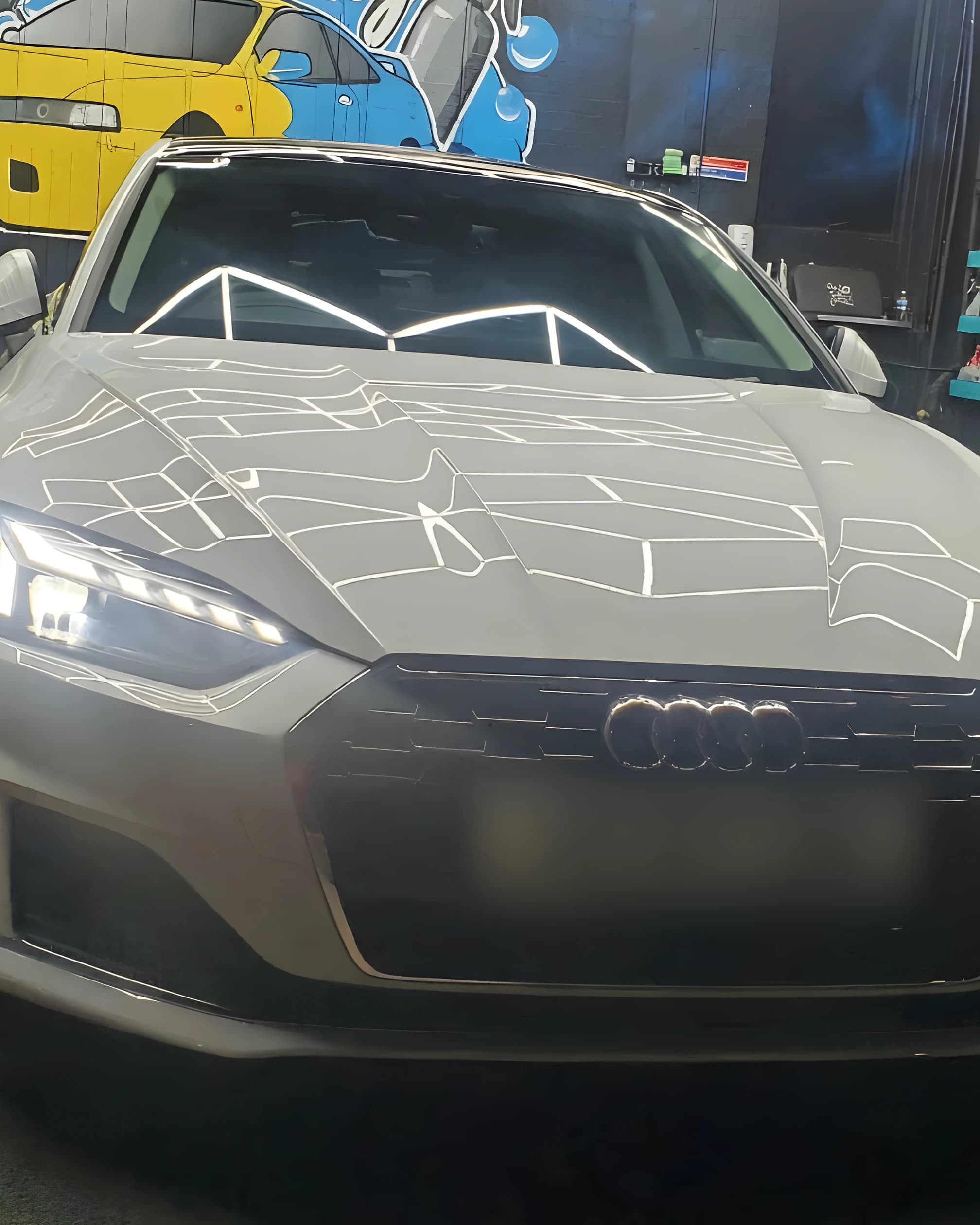 A grey coupe photographed head-on in the studio
