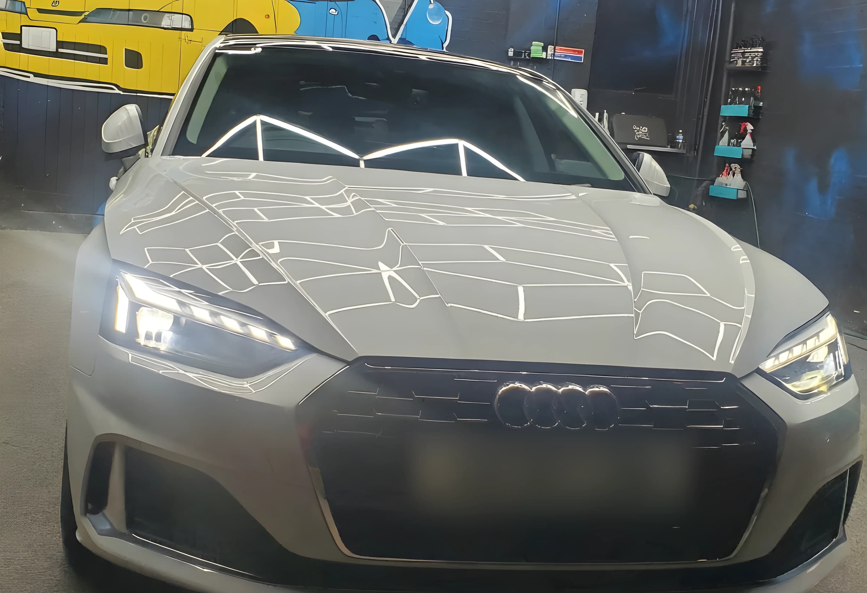 A grey coupe lit by the studio's hexagonal lighting