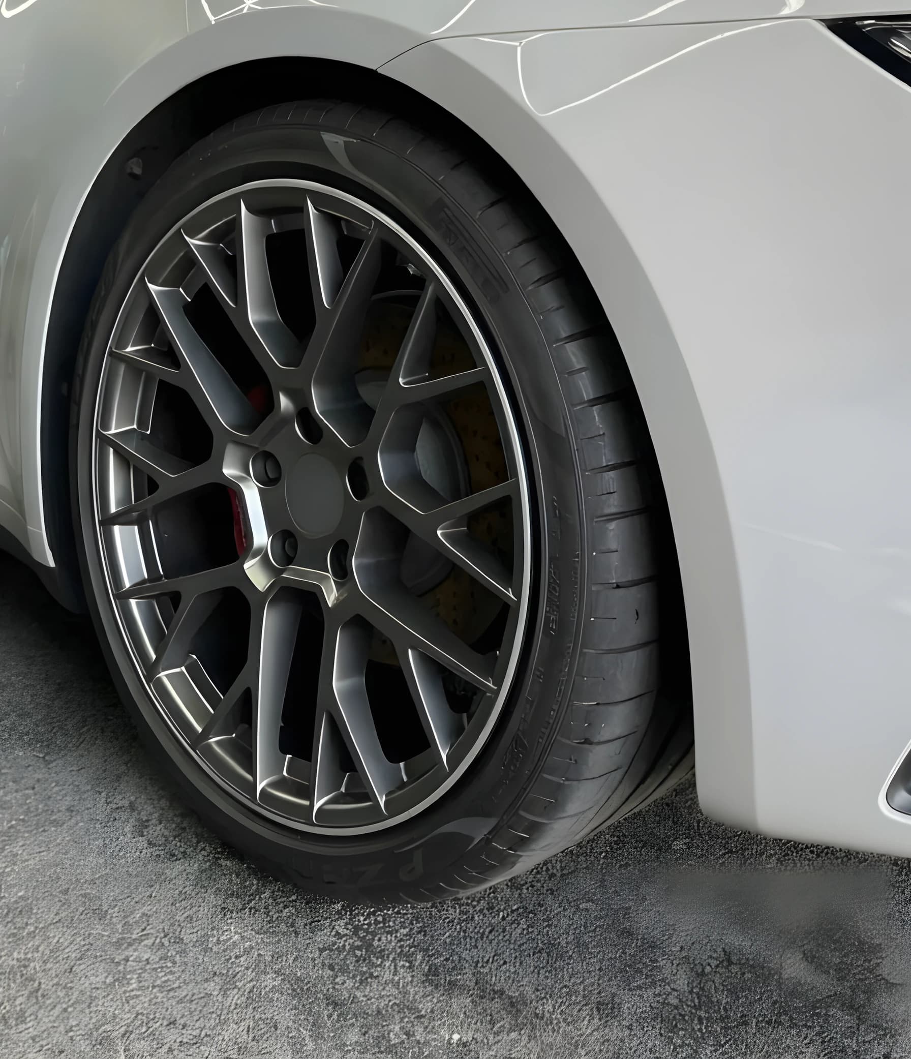 Close detail of an alloy wheel, tyre and arch on a silver sports car