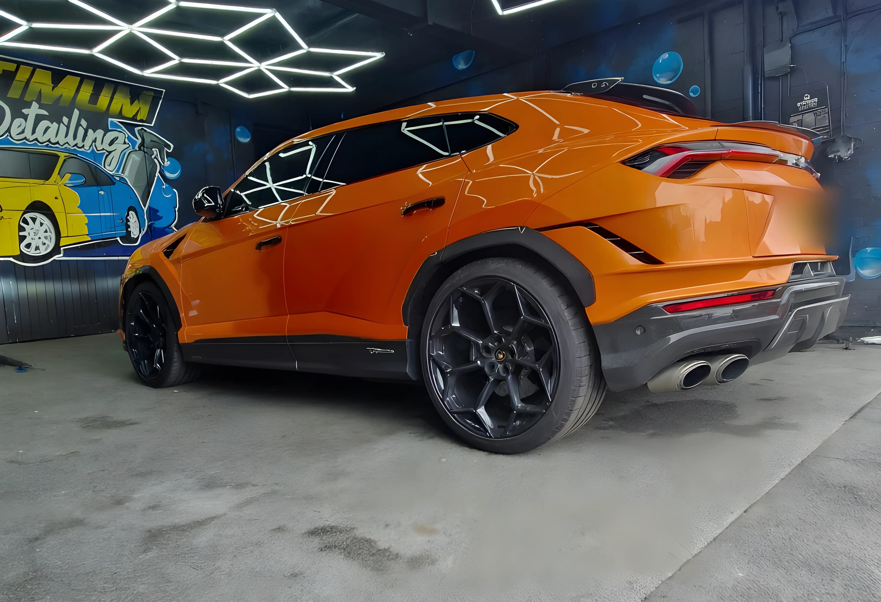 An orange performance SUV in the Optimum Detailing studio