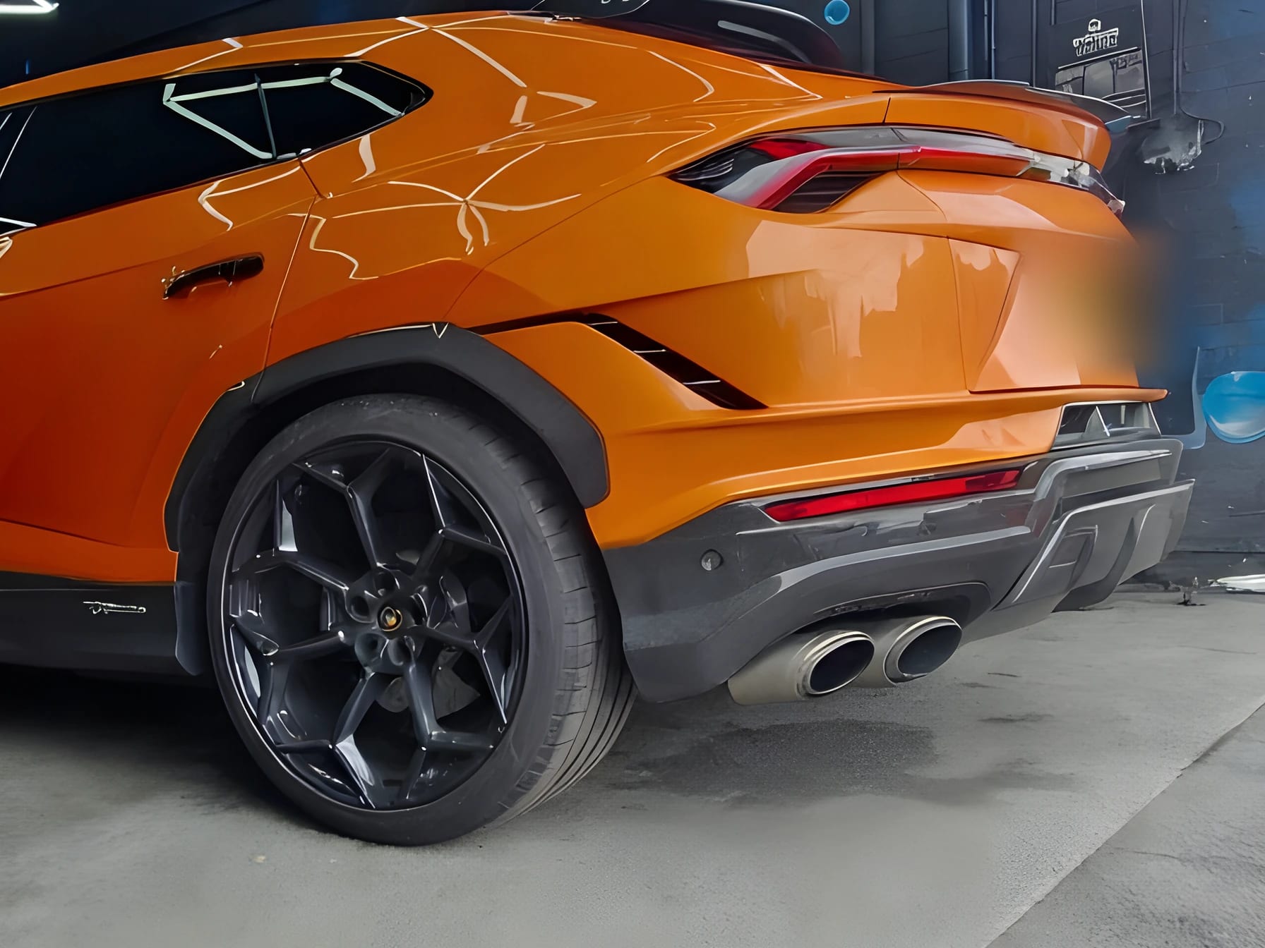 Rear quarter and exhaust detail of an orange performance SUV