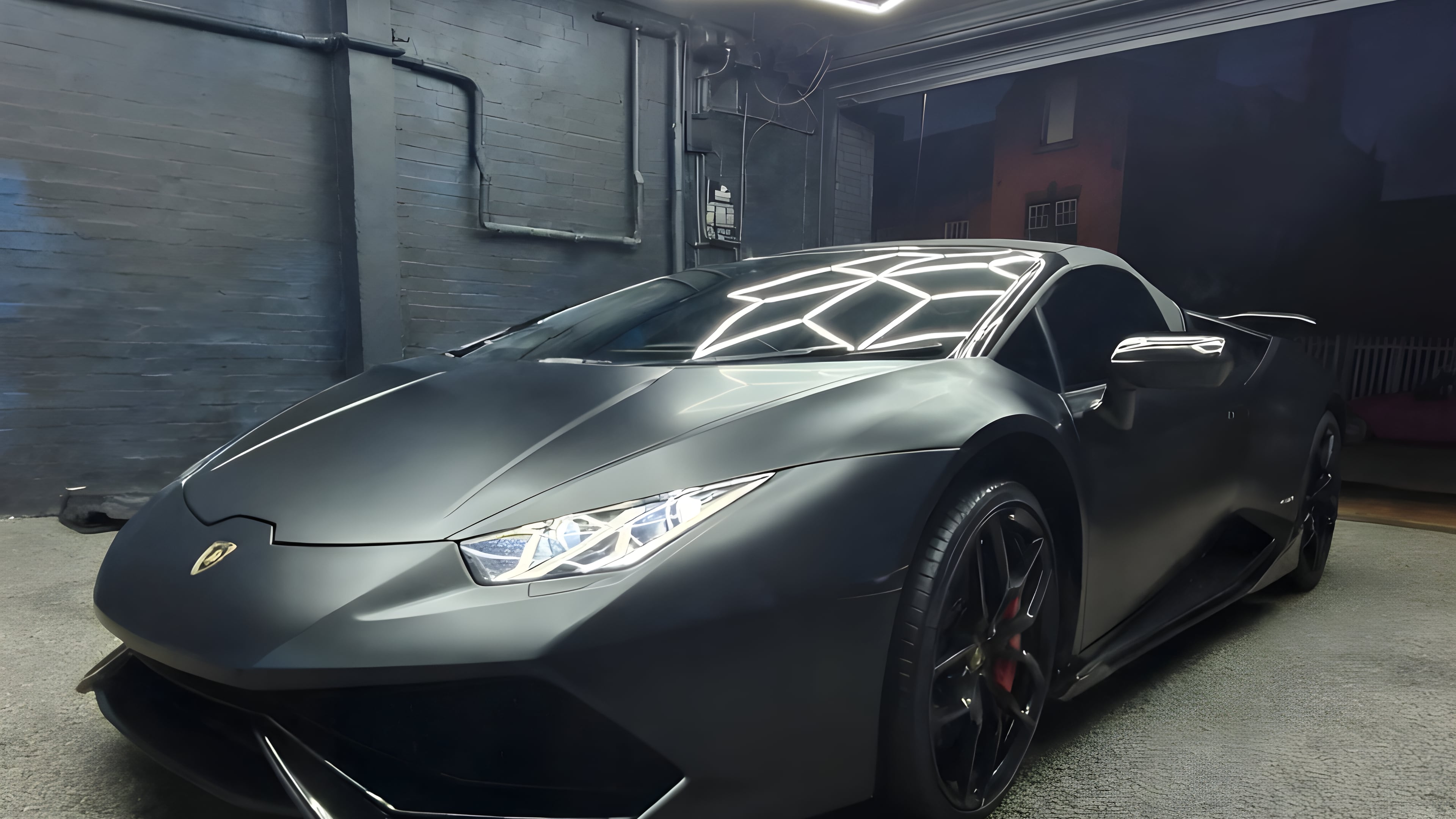 A matte black supercar under the hexagonal studio lighting at Optimum Detailing in Leicester